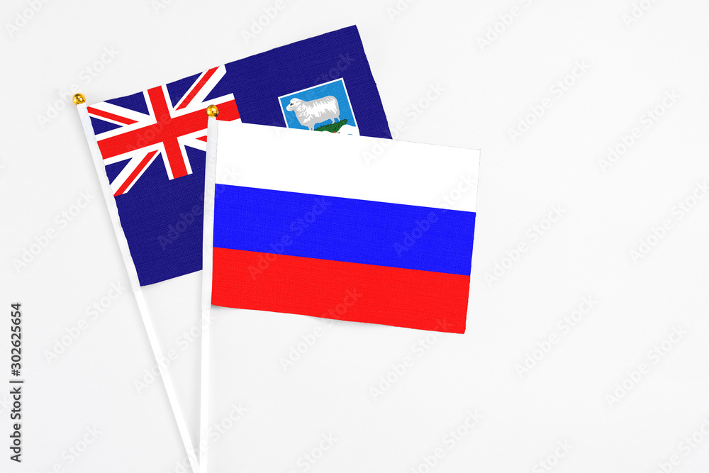 Russia and Falkland Islands stick flags on white background. High quality fabric, miniature national flag. Peaceful global concept.White floor for copy space. Russia and Falkland Islands stick flags on white background. High quality fabric, miniature national flag. Peaceful global concept.White floor for copy space.