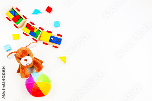 Baby kids toys background. Toy puppy, wooden train, colorful bricks on white table