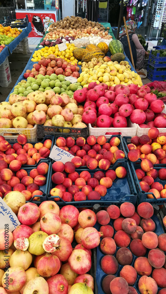A trading place in the Turkish market, a counter filled with fresh fruits and vegetables: pomegranate, nectarine, peach, pear, apple, melon, lemon, potatoes and onions