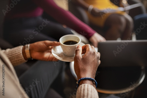 Close up of black african business man holding coffee cup in diverse meeting