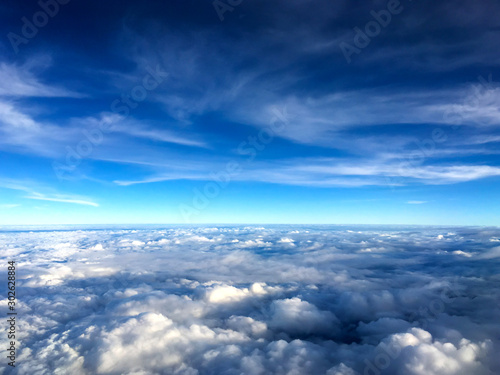 Fototapeta Naklejka Na Ścianę i Meble -  Clouds and sky as seen through window of an aircraft.Airplane wing in the blue sky above the clouds.