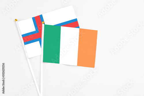 Ireland and Faroe Islands stick flags on white background. High quality fabric, miniature national flag. Peaceful global concept.White floor for copy space.