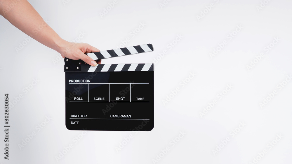 A man with hands is holding black Clapperboard or movie slate. it use in video production ,film, cinema industry.It is white background.