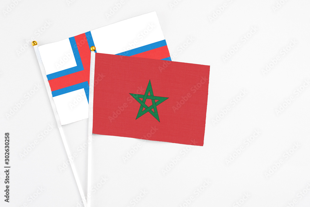 Morocco and Faroe Islands stick flags on white background. High quality fabric, miniature national flag. Peaceful global concept.White floor for copy space. Morocco and Faroe Islands stick flags on white background. High quality fabric, miniature national flag. Peaceful global concept.White floor for copy space.