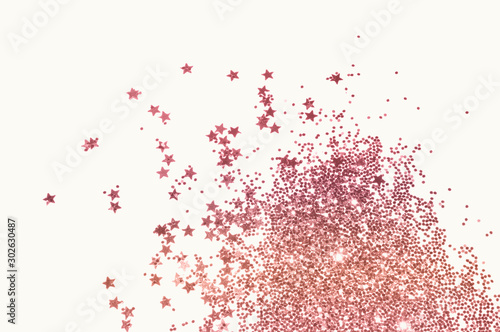 Pink glitter and glittering stars on light gray background