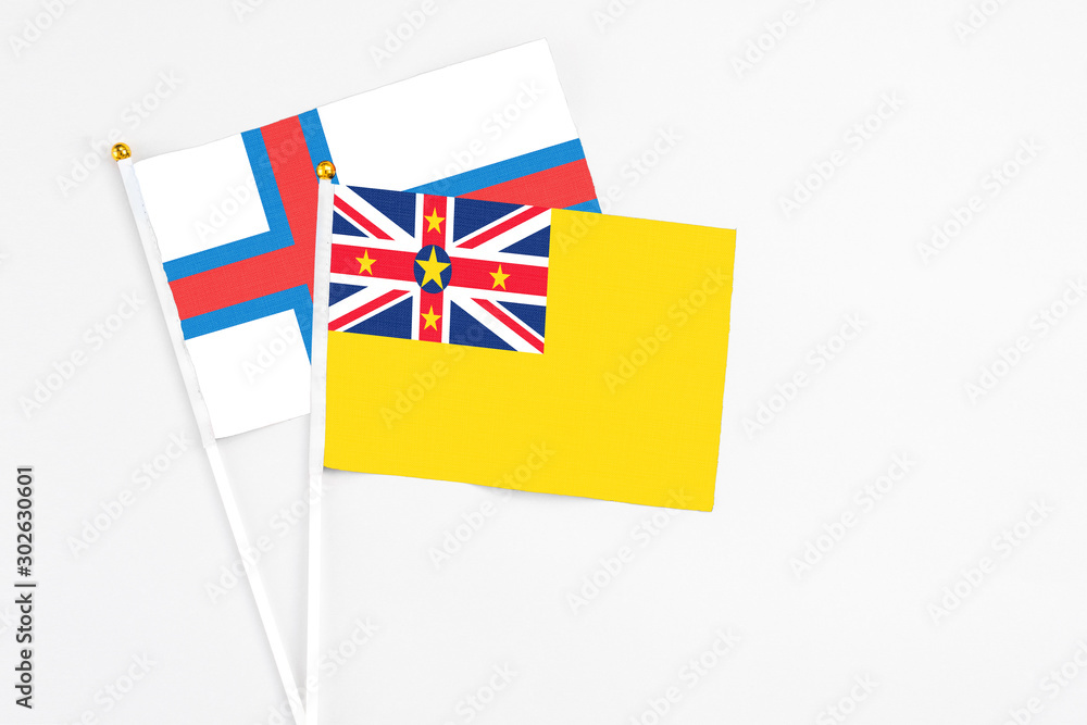 Niue and Faroe Islands stick flags on white background. High quality fabric, miniature national flag. Peaceful global concept.White floor for copy space. Niue and Faroe Islands stick flags on white background. High quality fabric, miniature national flag. Peaceful global concept.White floor for copy space.