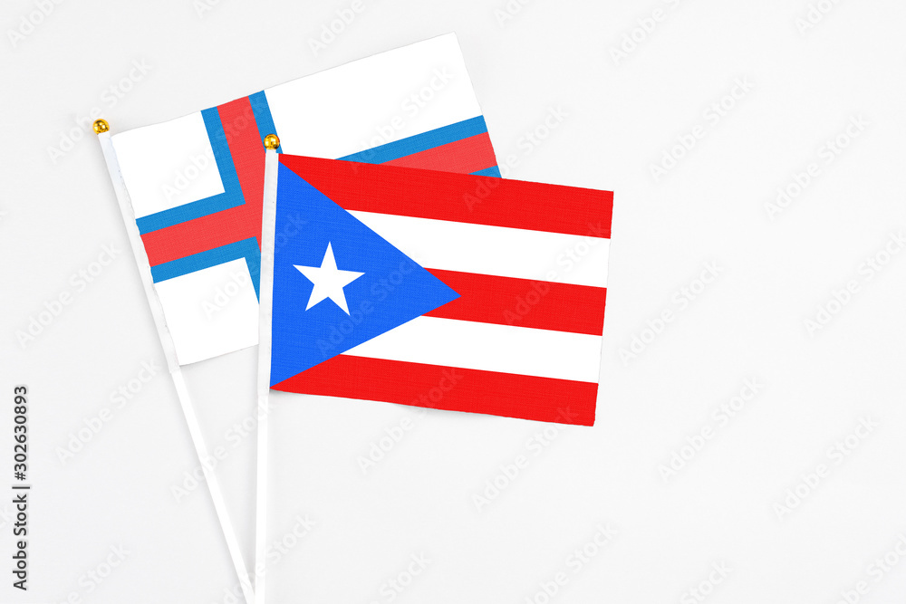Puerto Rico and Faroe Islands stick flags on white background. High quality fabric, miniature national flag. Peaceful global concept.White floor for copy space. Puerto Rico and Faroe Islands stick flags on white background. High quality fabric, miniature national flag. Peaceful global concept.White floor for copy space.