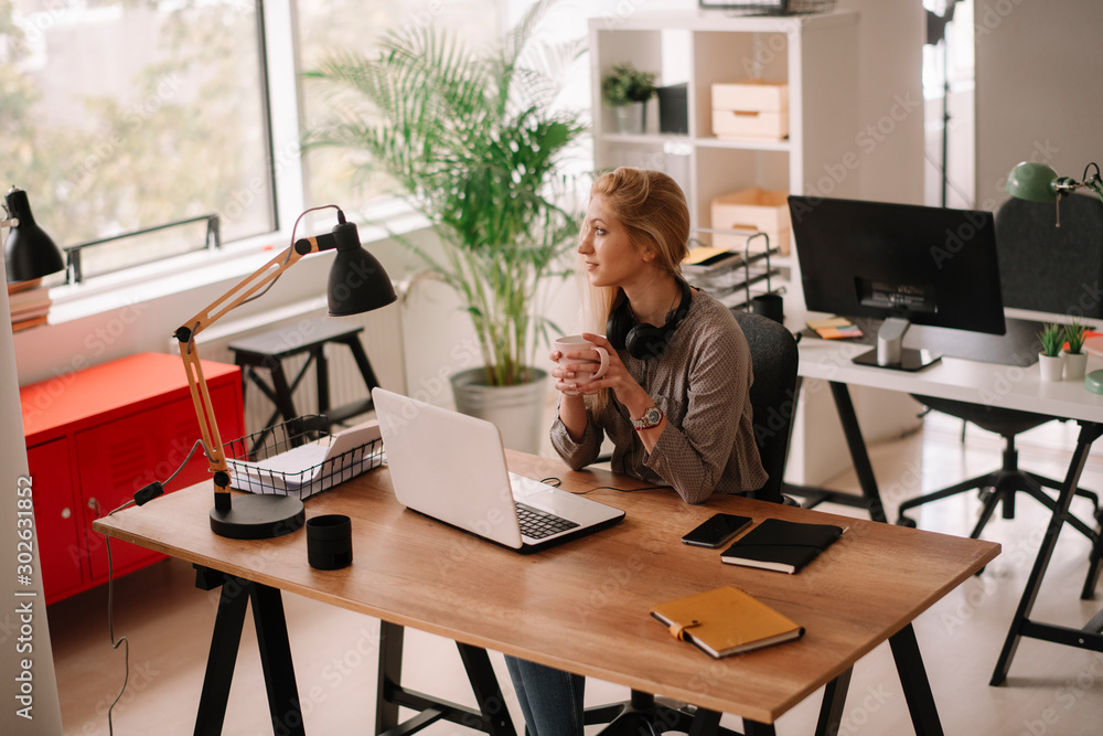 Young businesswoman in office. Beautiful woman with headphones. Young businesswoman in office. Beautiful woman with headphones.