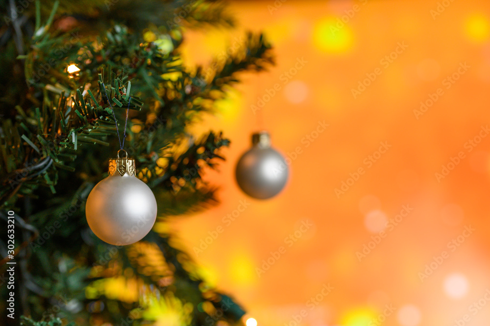 Christmas toys on the Christmas tree, on an orange background with snow. New Year or Christmas card