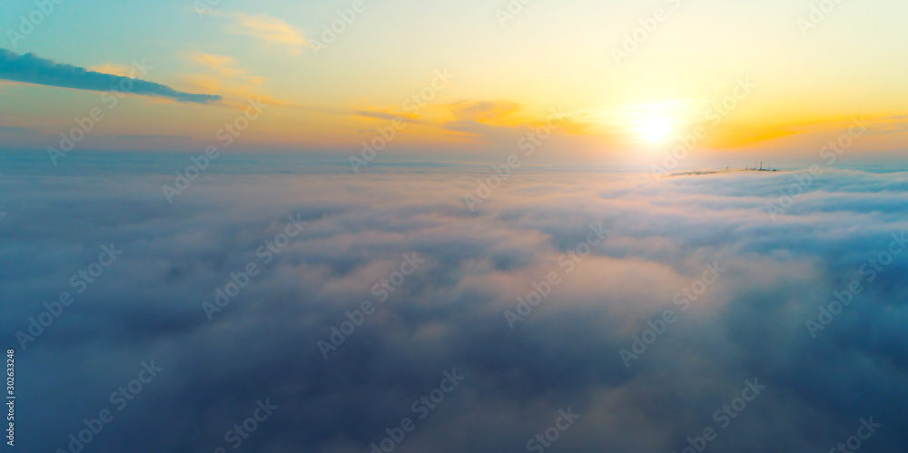 Beautiful sunset, above clouds. Aerial shot by a drone.
