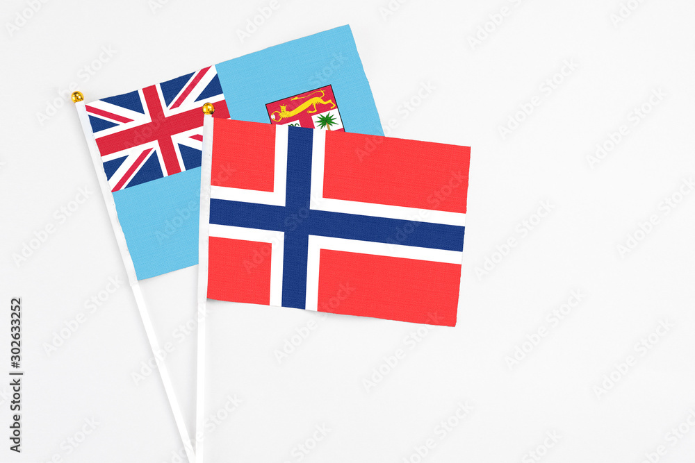 Bouvet Islands and Fiji stick flags on white background. High quality fabric, miniature national flag. Peaceful global concept.White floor for copy space. Bouvet Islands and Fiji stick flags on white background. High quality fabric, miniature national flag. Peaceful global concept.White floor for copy space.