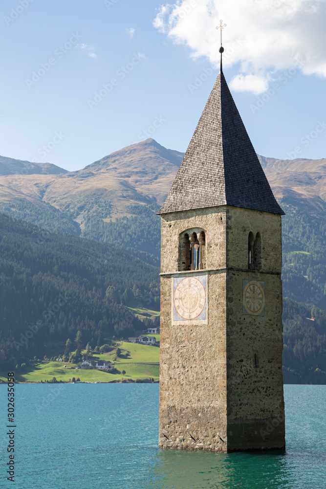 The bell tower submerged by the water in the Resia lake. Alps, Italy.