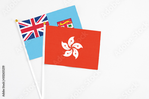 Hong Kong and Fiji stick flags on white background. High quality fabric, miniature national flag. Peaceful global concept.White floor for copy space.