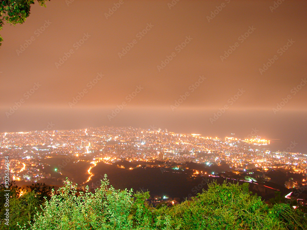 Fototapeta premium Night city background, beautiful urban cityscape, Beirut with street lights, high buildings and skyscrapers,panoramic dark town pattern, Middle East , Lebanon