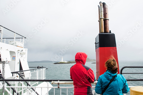 Two tourists looks at the Lighthouse of Lismore during a ferry crossing in the inner Hebrides photo