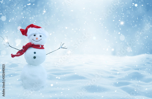 Happy  snowman standing in christmas landscape.Snow background.Winter fairytale.Merry christmas and happy new year greeting card with copy-space. © Lilya