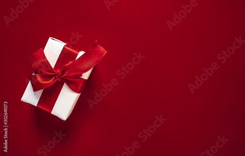 one gift box on a red background. Top view with copy space.
