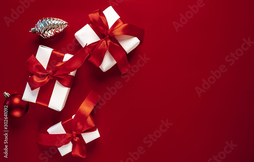 Christmas card with gift boxes on a red background. White Christmas gift boxes on a red background. Top view with place for your congratulations.