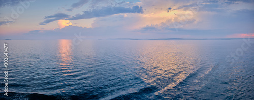 Panorama with the sun penetrates the clouds and the light reflects in the sea
