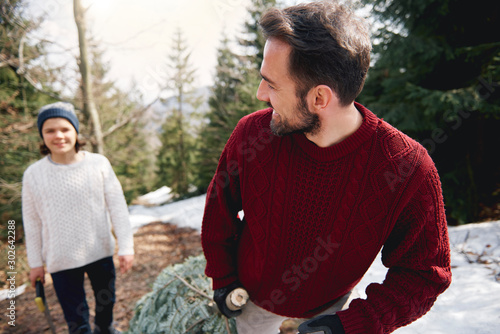 Father and his son cutting the christmas tree