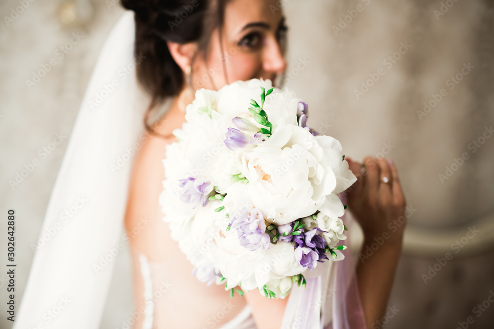 Naklejka premium Beautiful bride wearing fashion wedding dress with feathers with luxury delight make-up and hairstyle, studio indoor photo shoot