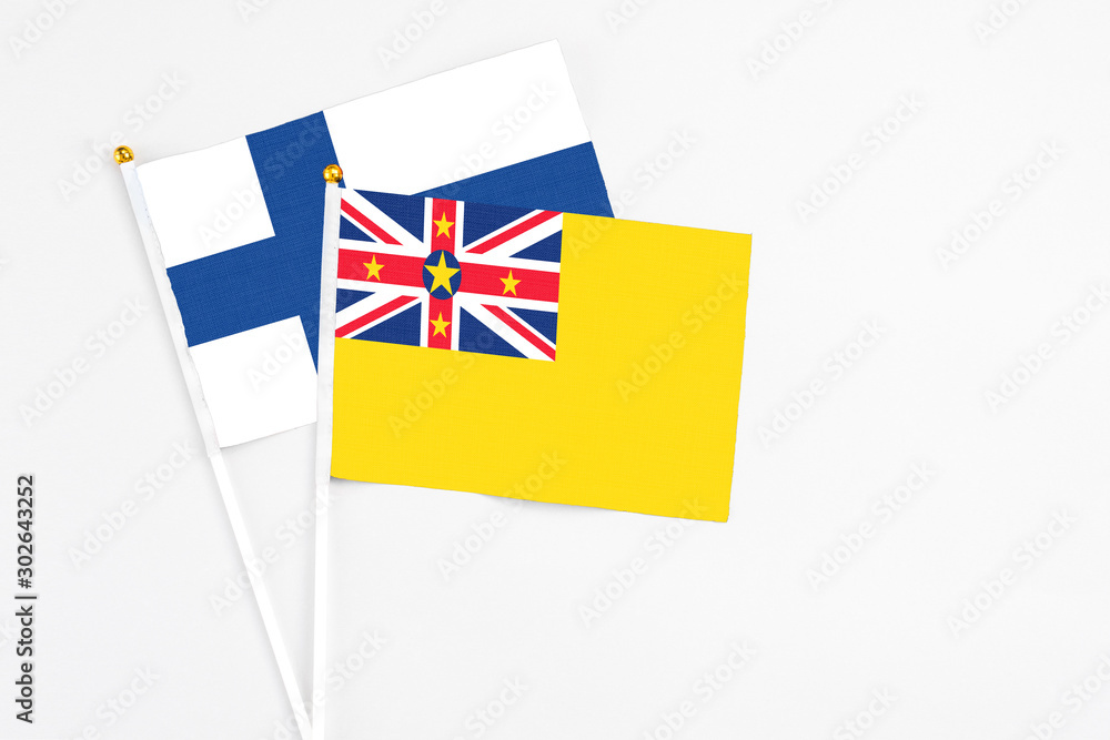 Niue and Finland stick flags on white background. High quality fabric, miniature national flag. Peaceful global concept.White floor for copy space. Niue and Finland stick flags on white background. High quality fabric, miniature national flag. Peaceful global concept.White floor for copy space.