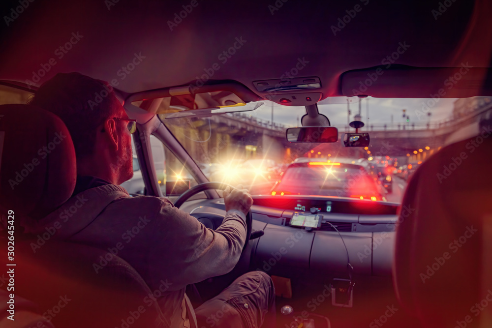 Driving a car in the city at night in traffic jams - obrazy, fototapety, plakaty 