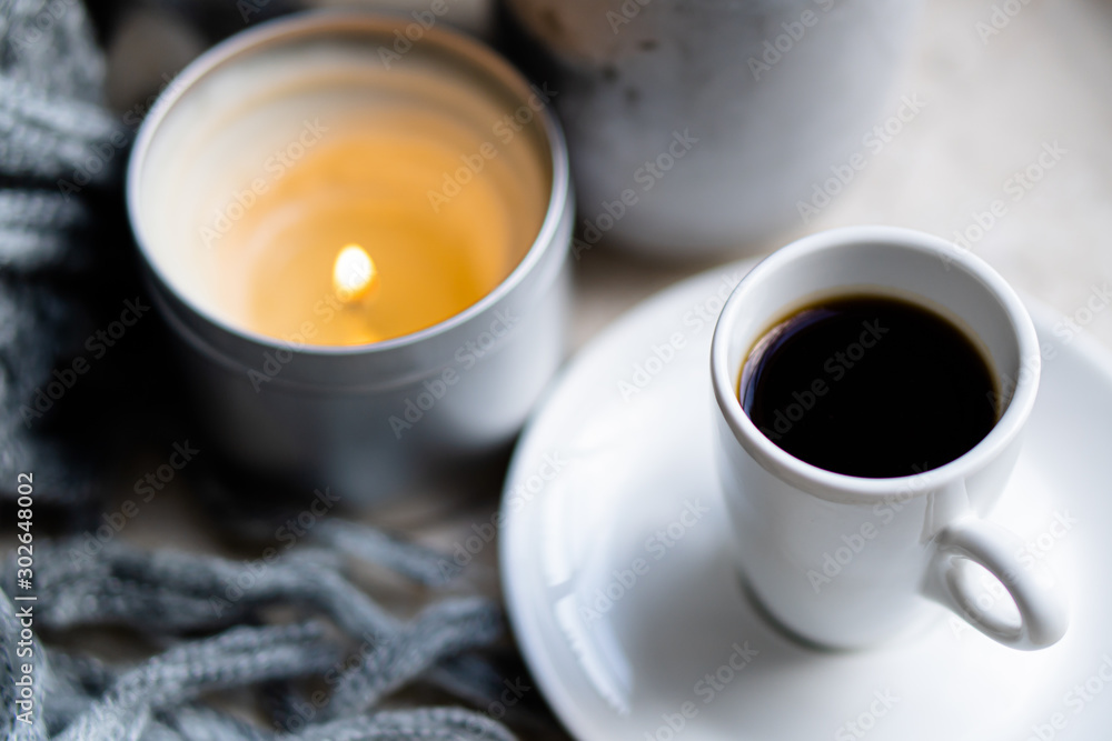 Burning candles, gray blanket and cup of coffee Burning candles, gray blanket and cup of coffee
