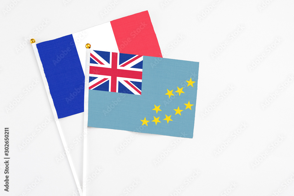 Tuvalu and France stick flags on white background. High quality fabric, miniature national flag. Peaceful global concept.White floor for copy space. Tuvalu and France stick flags on white background. High quality fabric, miniature national flag. Peaceful global concept.White floor for copy space.