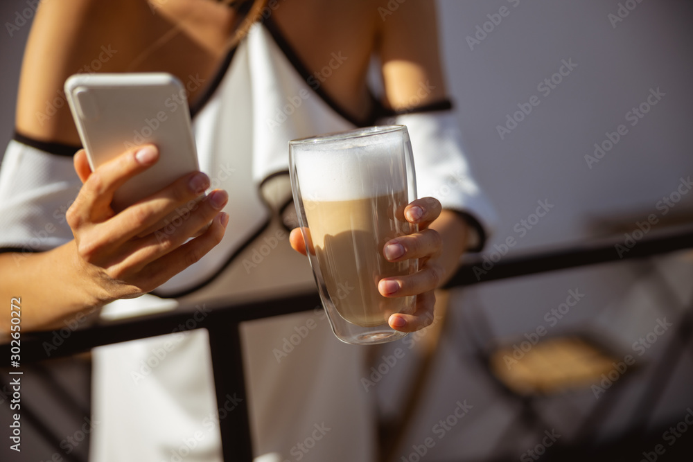 Woman having her morning coffee and texting Woman having her morning coffee and texting