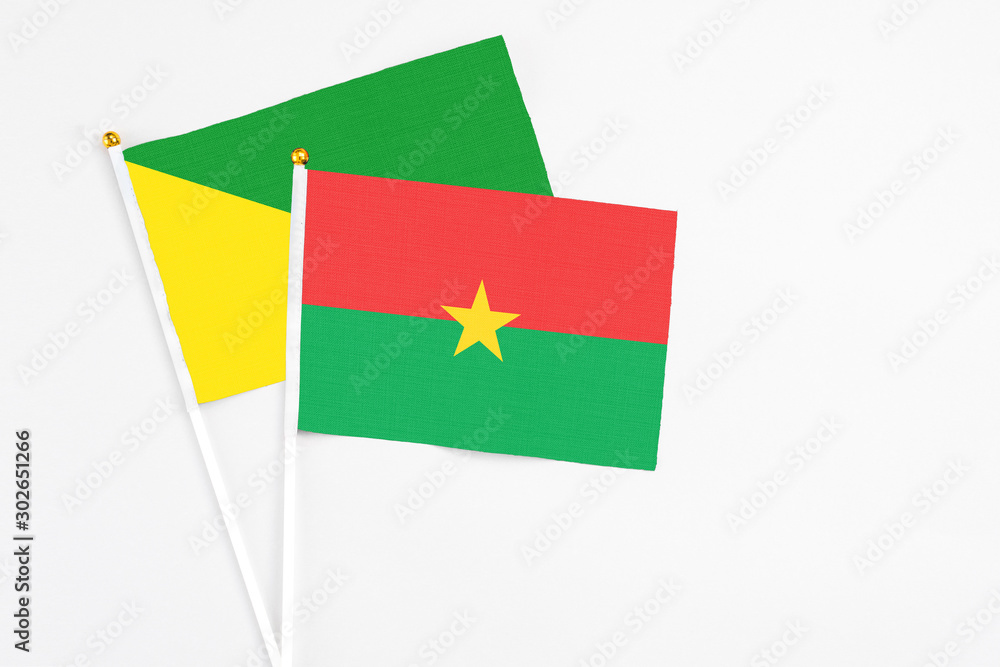 Burkina Faso and French Guiana stick flags on white background. High quality fabric, miniature national flag. Peaceful global concept.White floor for copy space. Burkina Faso and French Guiana stick flags on white background. High quality fabric, miniature national flag. Peaceful global concept.White floor for copy space.