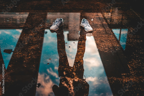 Creative play with reflections in a puddle, empty shoes