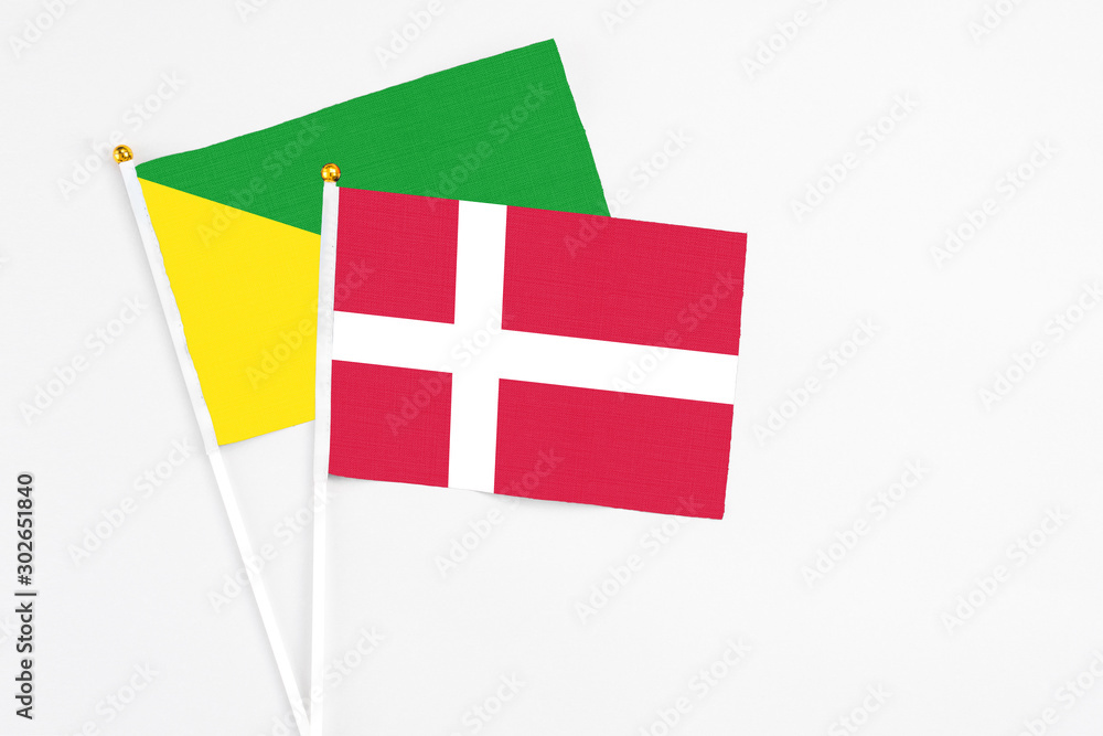 Denmark and French Guiana stick flags on white background. High quality fabric, miniature national flag. Peaceful global concept.White floor for copy space.