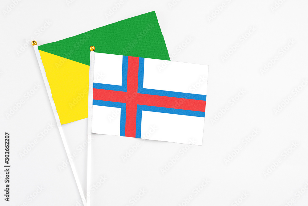 Faroe Islands and French Guiana stick flags on white background. High quality fabric, miniature national flag. Peaceful global concept.White floor for copy space.