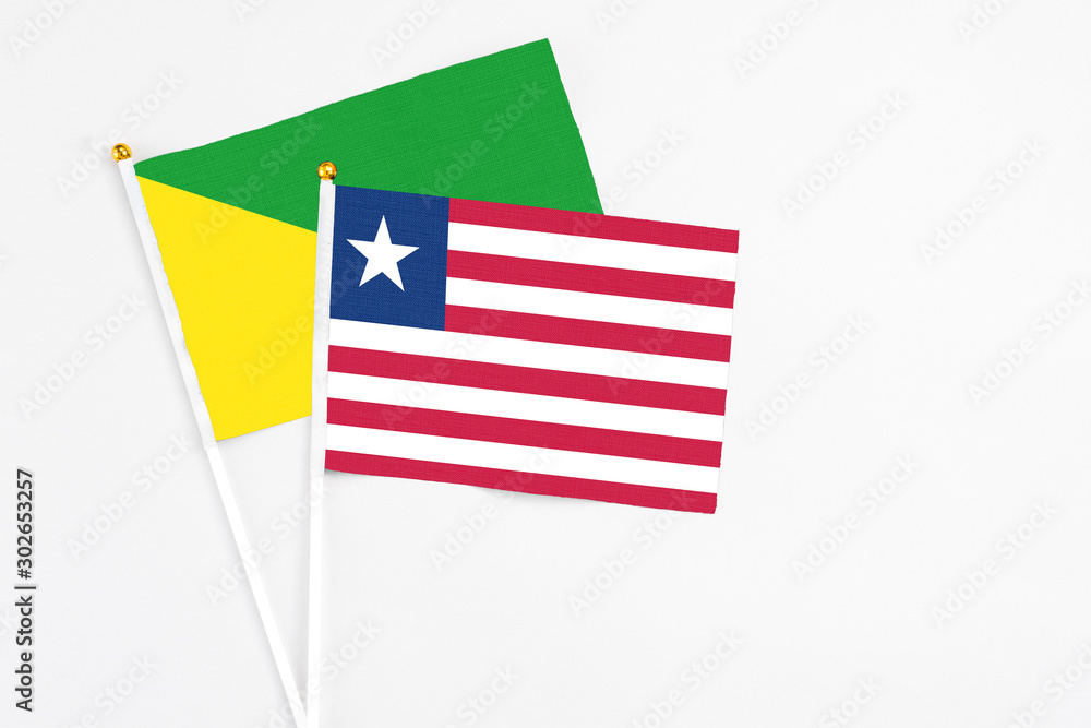 Liberia and French Guiana stick flags on white background. High quality fabric, miniature national flag. Peaceful global concept.White floor for copy space. Liberia and French Guiana stick flags on white background. High quality fabric, miniature national flag. Peaceful global concept.White floor for copy space.