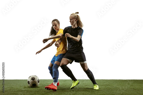 Young female soccer or football players with long hair in sportwear and boots training on white background. Concept of healthy lifestyle, professional sport, motion, movement. Fight for goal. © master1305