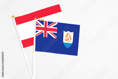 Anguilla and French Polynesia stick flags on white background. High quality fabric, miniature national flag. Peaceful global concept.White floor for copy space.