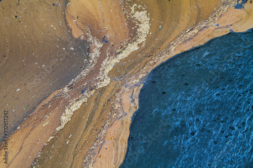 Photos Abstract picture of a brown floating surface layer on blue water