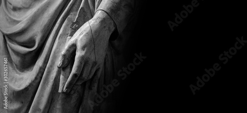 Man hand on antique tunic. Stone statue detail of human hand. Folds in the fabric. Copyspace for text