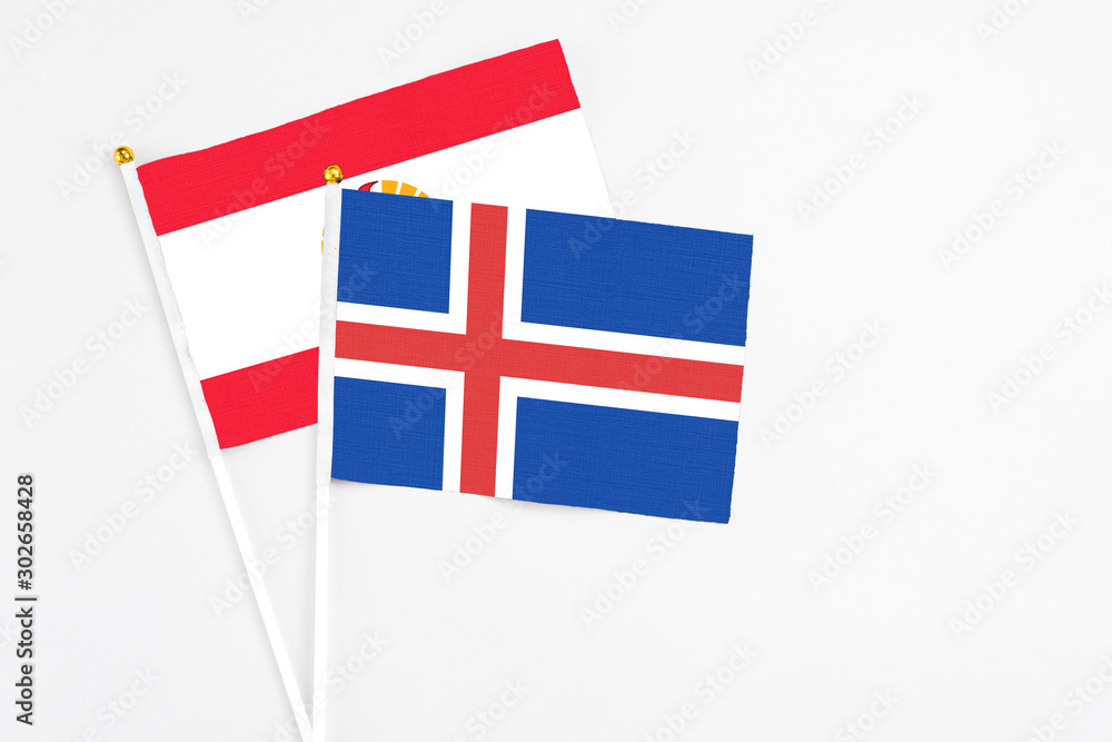 Iceland and French Polynesia stick flags on white background. High quality fabric, miniature national flag. Peaceful global concept.White floor for copy space.