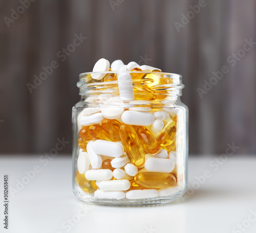 Pills in a jar on wooden background photo
