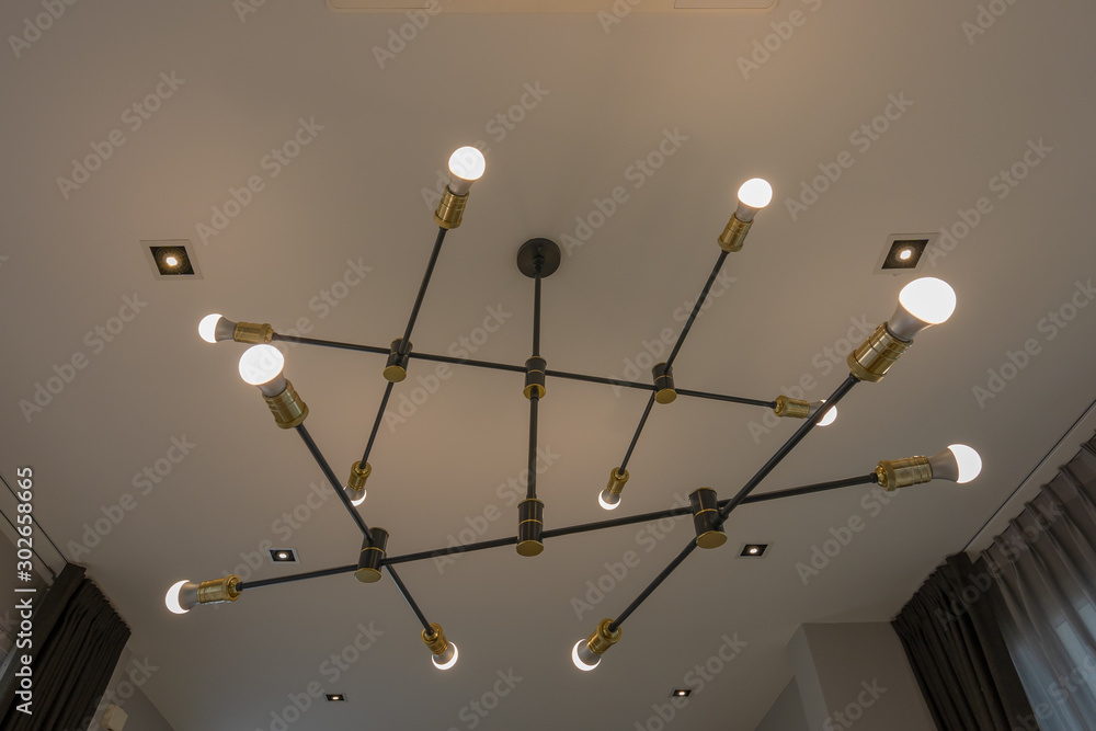 Modern chandelier ceiling light bulbs lamps design is the black metal rod  in diagonal lines decoration interior contemporary concept Stock Photo
