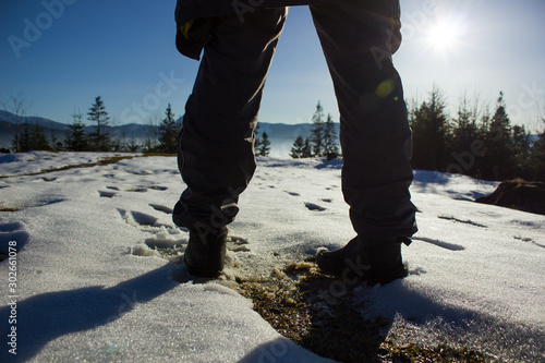 man in hiking boots on the winter mountains