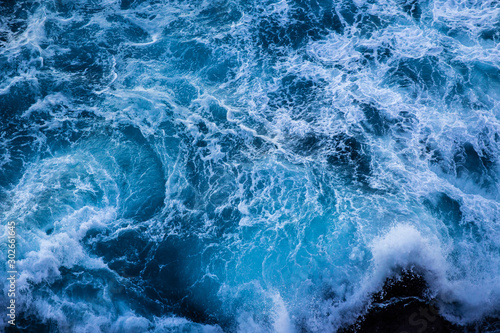 Fototapeta Naklejka Na Ścianę i Meble -  Violent energetic waves crashing on a rock in Sydney Australia. Light and dark blue water foaming whilst waves break to the shore. Deep Sea.