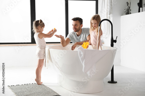 Young father with little daughters in bathroom