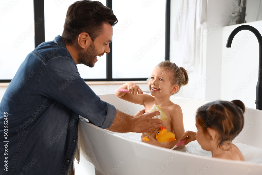 Young father with little daughters in bathroom - obrazy, fototapety, plakaty 