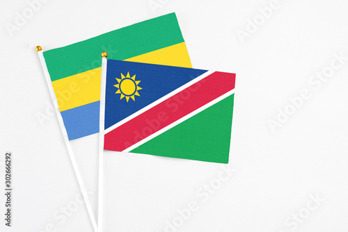 Namibia and Gabon stick flags on white background. High quality fabric  miniature national flag. Peaceful global concept.White floor for copy space.