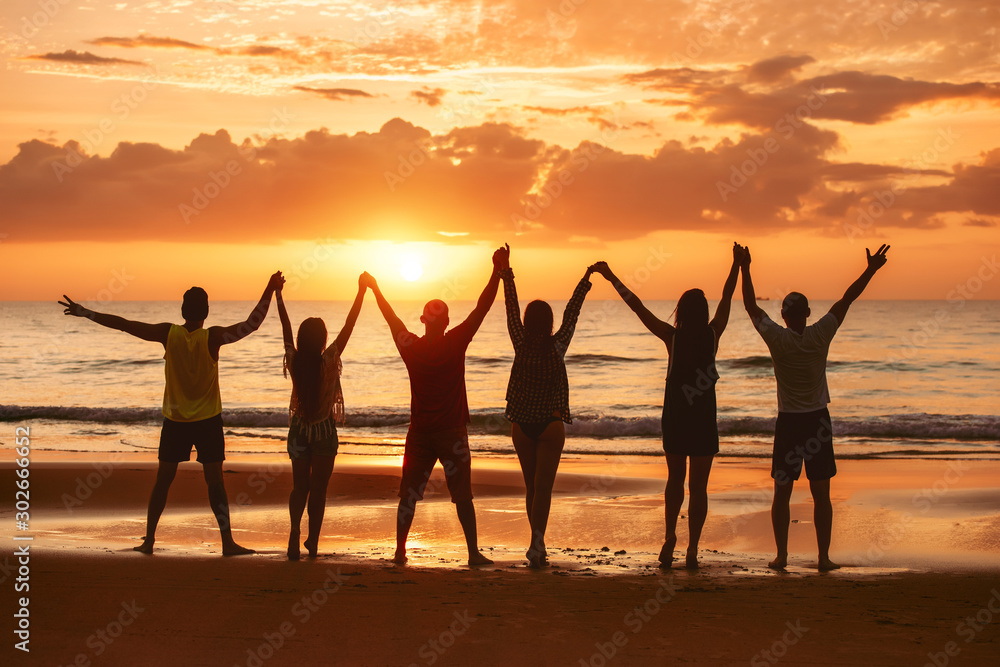 Φωτογραφία Happy friends raised arms together sunset sea