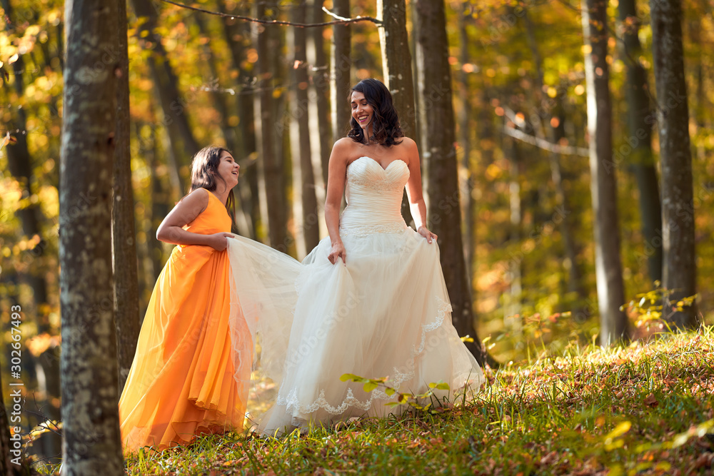 Bride and bridesmaid in the forest