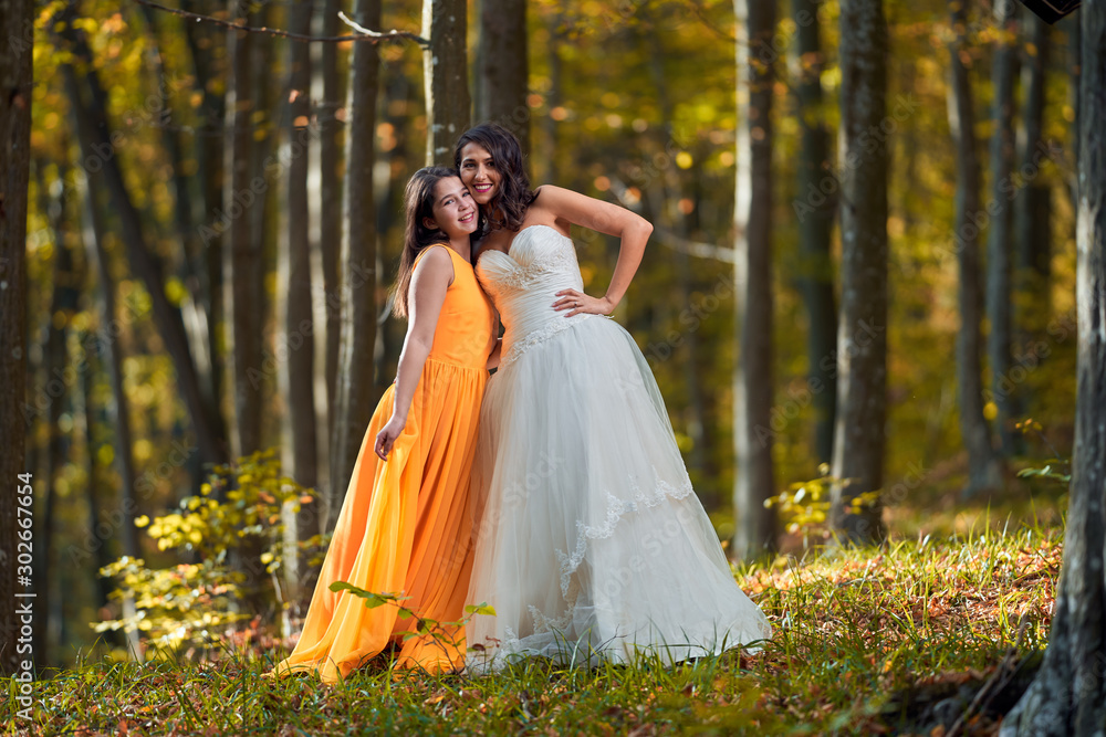 Bride and bridesmaid in the forest